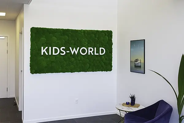 Lille mosvæg i reception med logo,